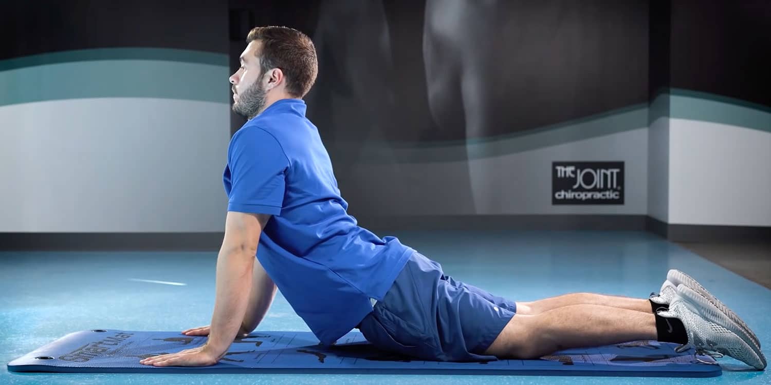 Man demonstrating the Prone Cobra, an exercise known for strengthening your core and improving posture. 