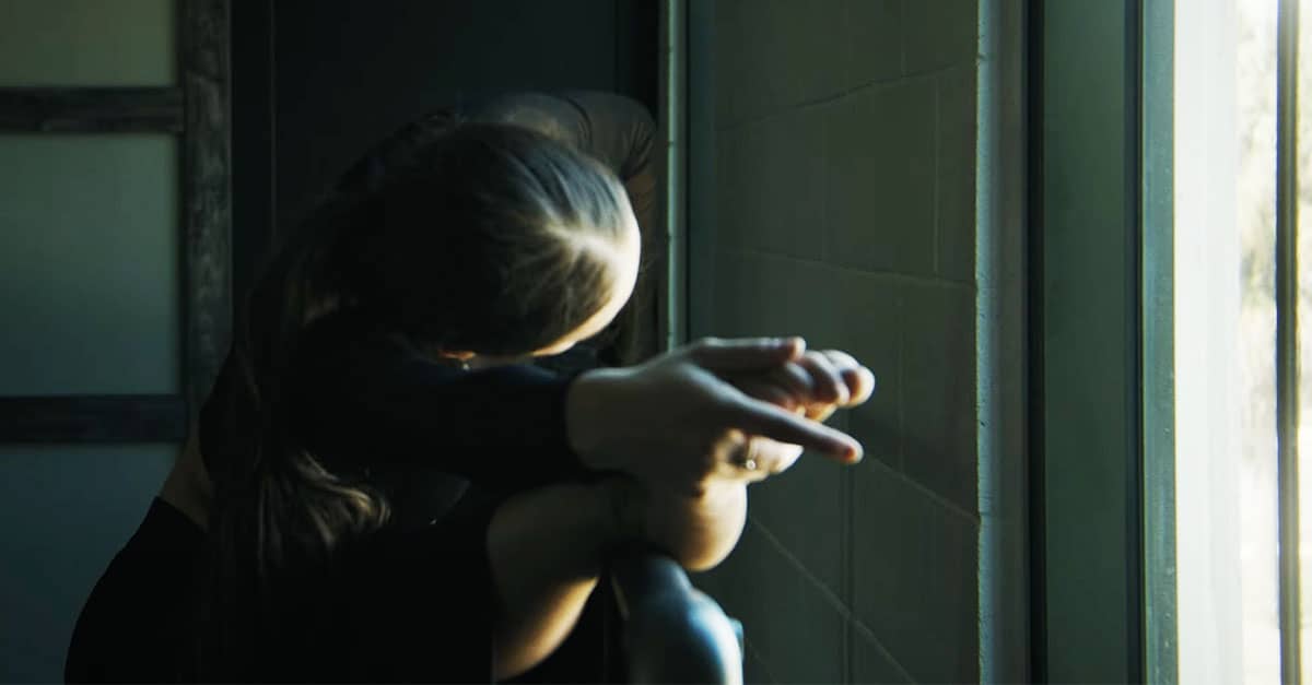 Lilliana, a young dancer, stretches at the barre in a softly lit studio, symbolizing her journey overcoming repetitive stress pain through chiropractic care for kids.